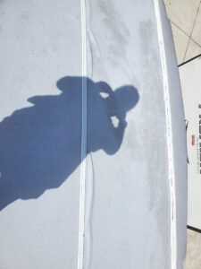 rv roof with wrinkles and shadow of person taking picture